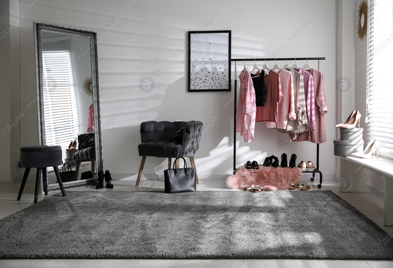 Photo of Dressing room interior with clothing rack and comfortable chair