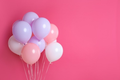 Photo of Colorful party balloons on pink background. Space for text