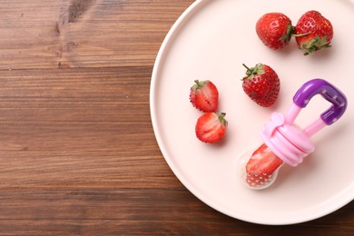 Nibbler with fresh strawberries on wooden table, top view. Space for text