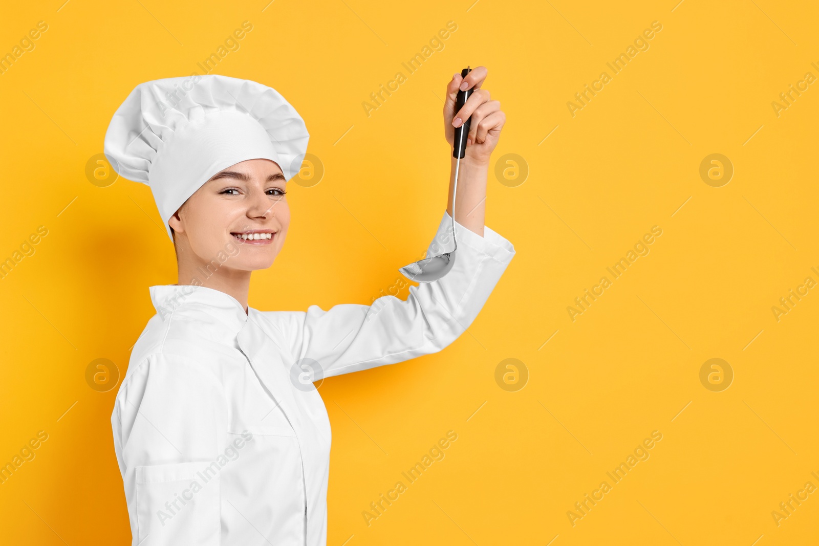 Photo of Professional chef with ladle on yellow background. Space for text