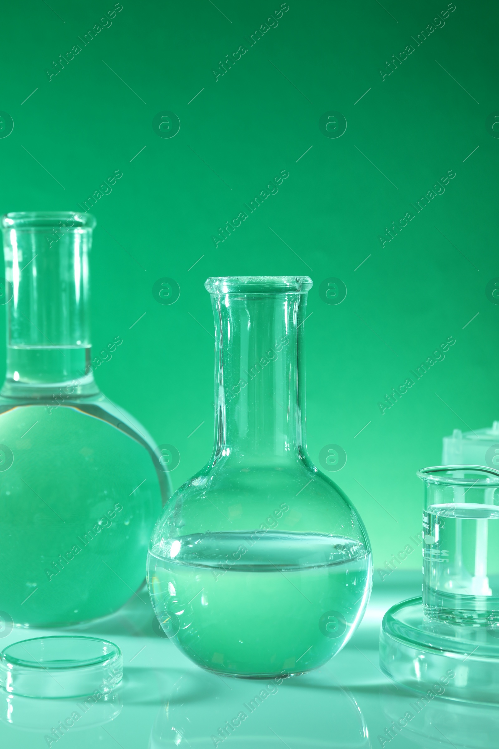 Photo of Laboratory analysis. Different glassware on table against green background