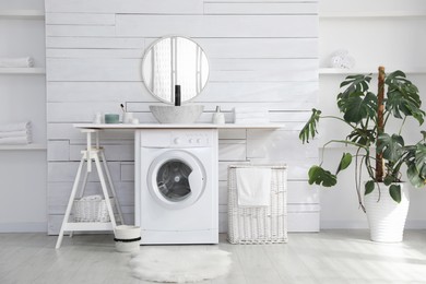 Photo of Stylish bathroom interior with modern washing machine