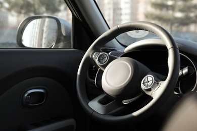 Photo of Black steering wheel inside of modern car