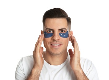 Man applying blue under eye patches on white background