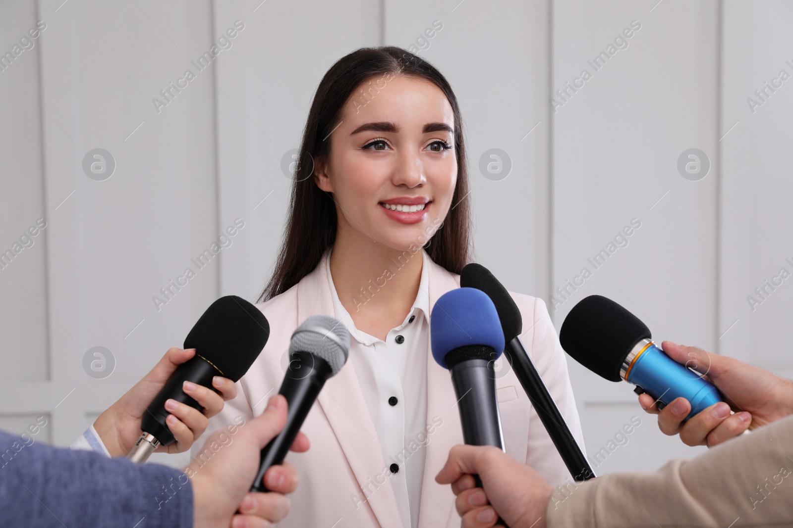 Photo of Happy business woman giving interview to journalists at official event