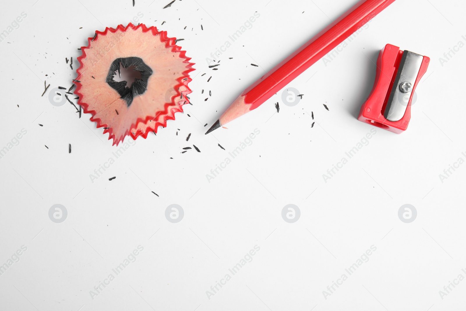 Photo of Pencil, sharpener and shaving on white background, top view