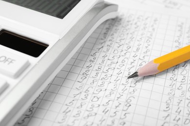 Photo of Calculator and pencil on document with data, closeup view