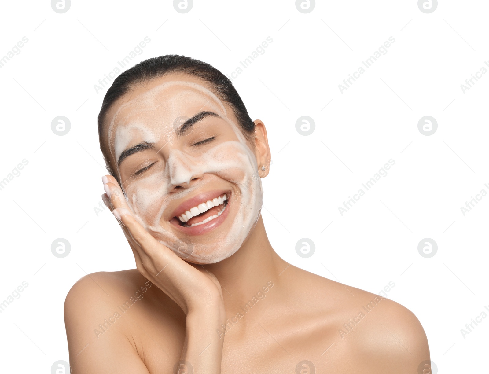 Photo of Happy young woman washing face with cosmetic product on white background