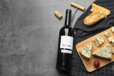 Photo of FLat lay composition with board of delicious blue cheese and wine on stone background. Space for text