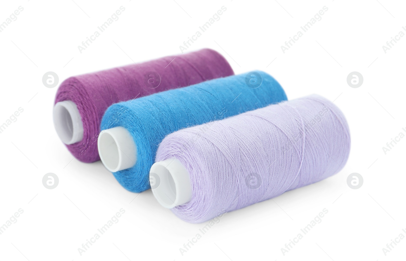 Photo of Different colorful sewing threads on white background