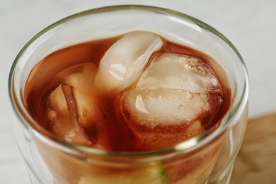 Photo of Glass of tasty ice tea with lime on white table, closeup