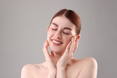 Portrait of smiling woman on grey background