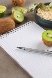 Photo of Healthy diet. Notebook, measuring tape, pen and products on grey table, closeup