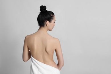 Photo of Back view of woman with perfect smooth skin on light background, space for text