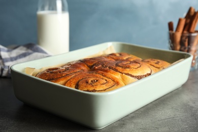 Baking dish with cinnamon rolls on table