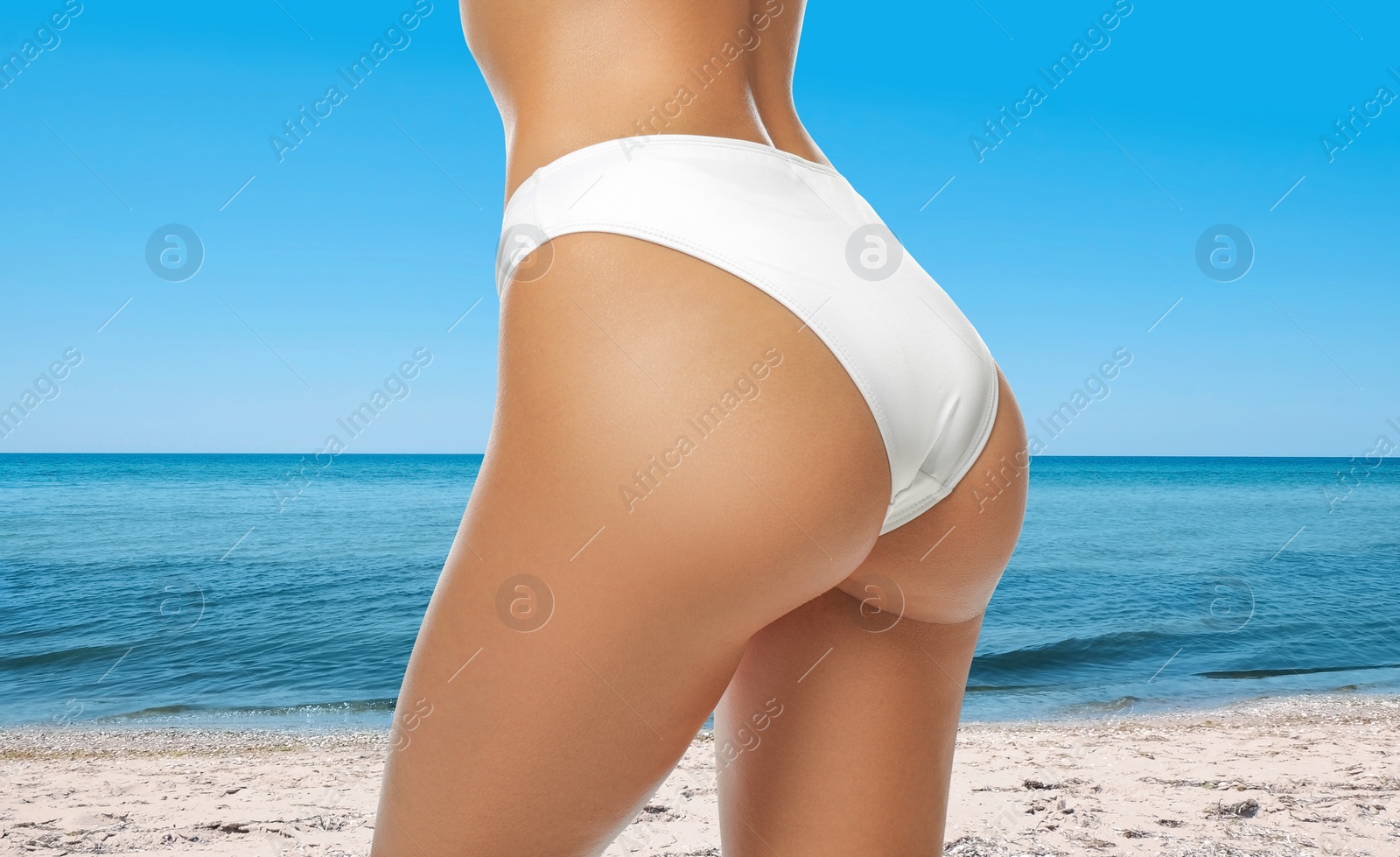 Image of Young woman with sexy body on sandy beach, closeup