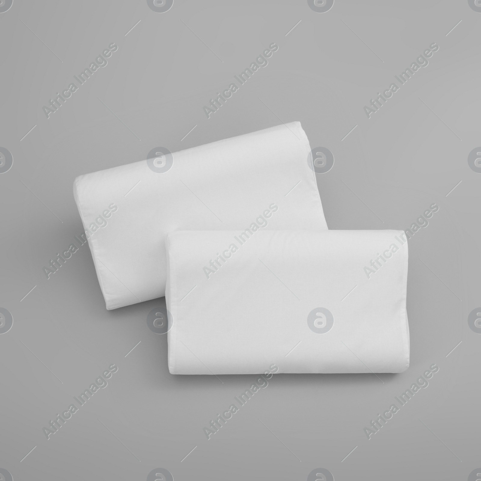 Photo of Clean soft orthopedic pillows on grey background, top view