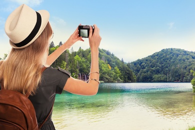 Image of Traveler with backpack taking photo during summer vacation trip