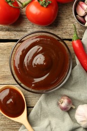 Photo of Flat lay composition with tasty barbeque sauce in bowl on wooden table