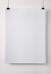 White blank poster hanging near light wall