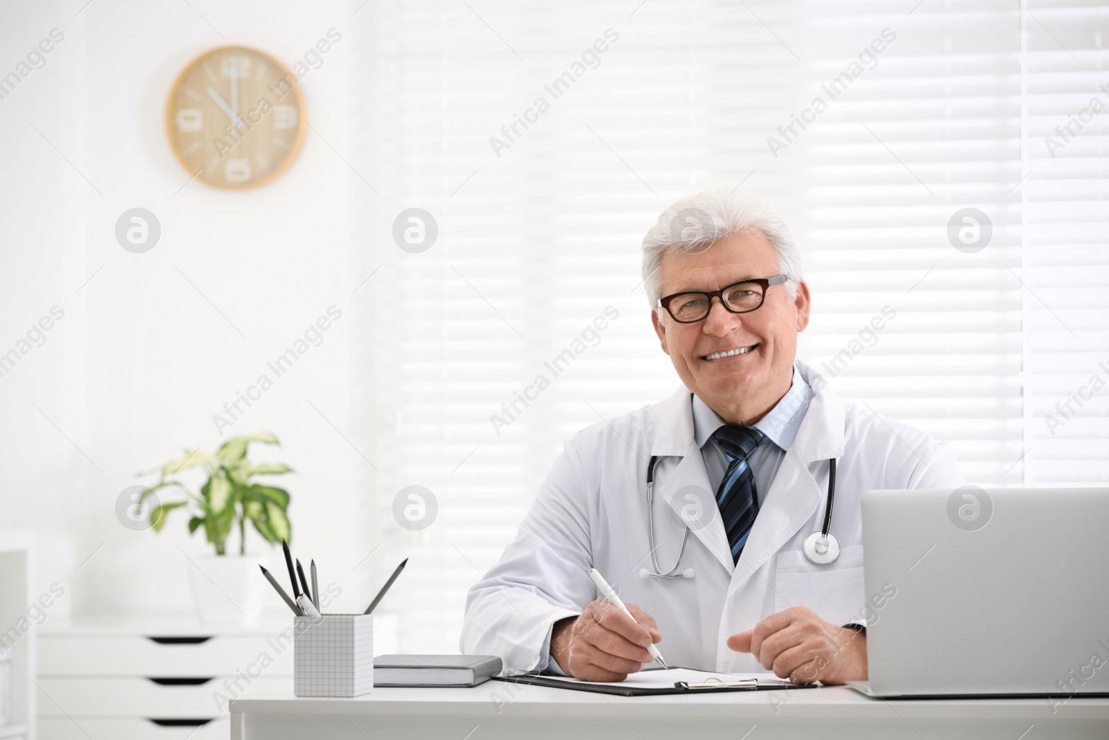 Photo of Portrait of senior doctor in white coat at workplace