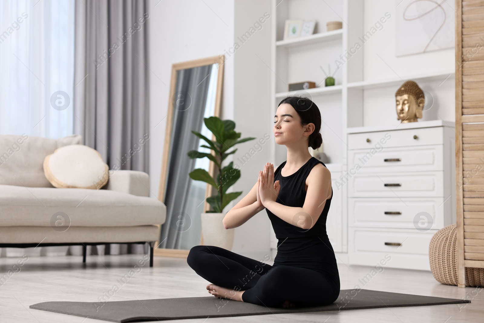 Photo of Beautiful girl meditating on yoga mat at home