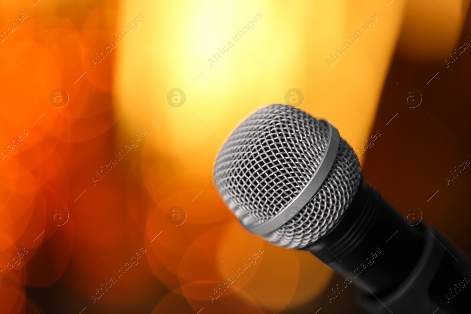 Photo of Microphone against festive lights, space for text. Musical equipment