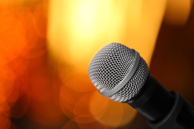 Microphone against festive lights, space for text. Musical equipment