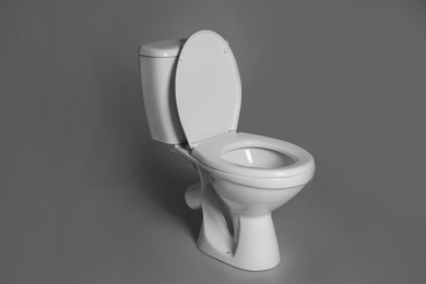 Photo of New ceramic toilet bowl on grey background