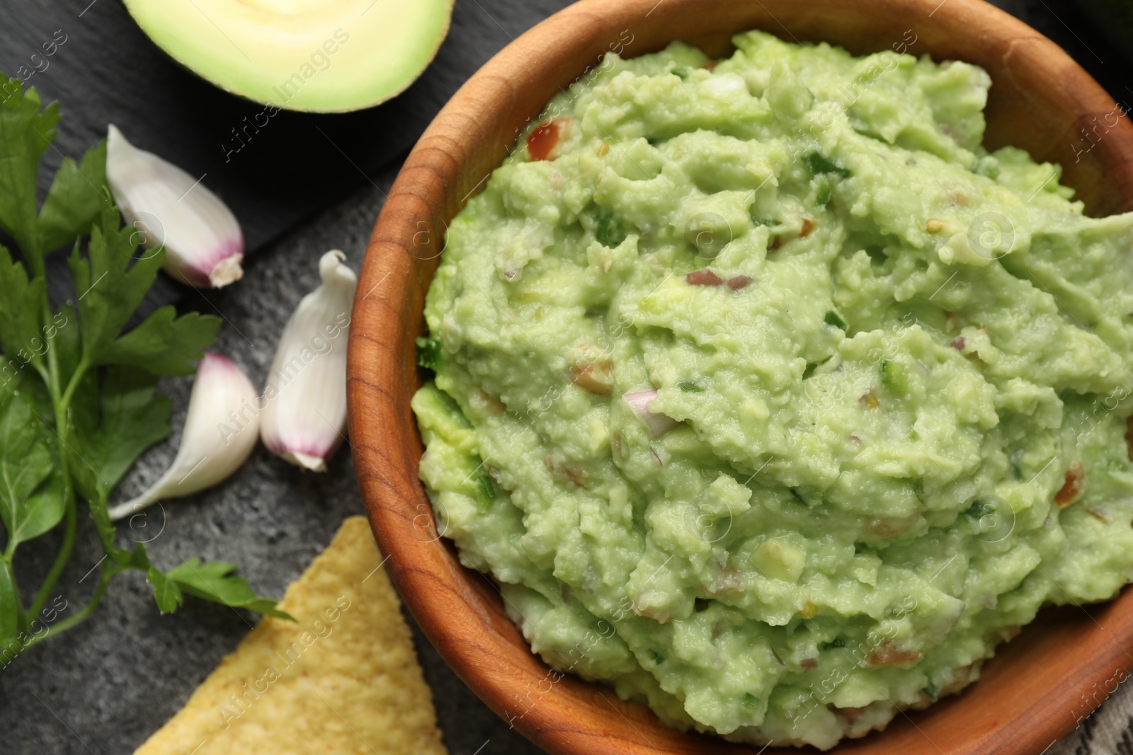 Photo of Delicious guacamole and ingredients on grey table, flat lay