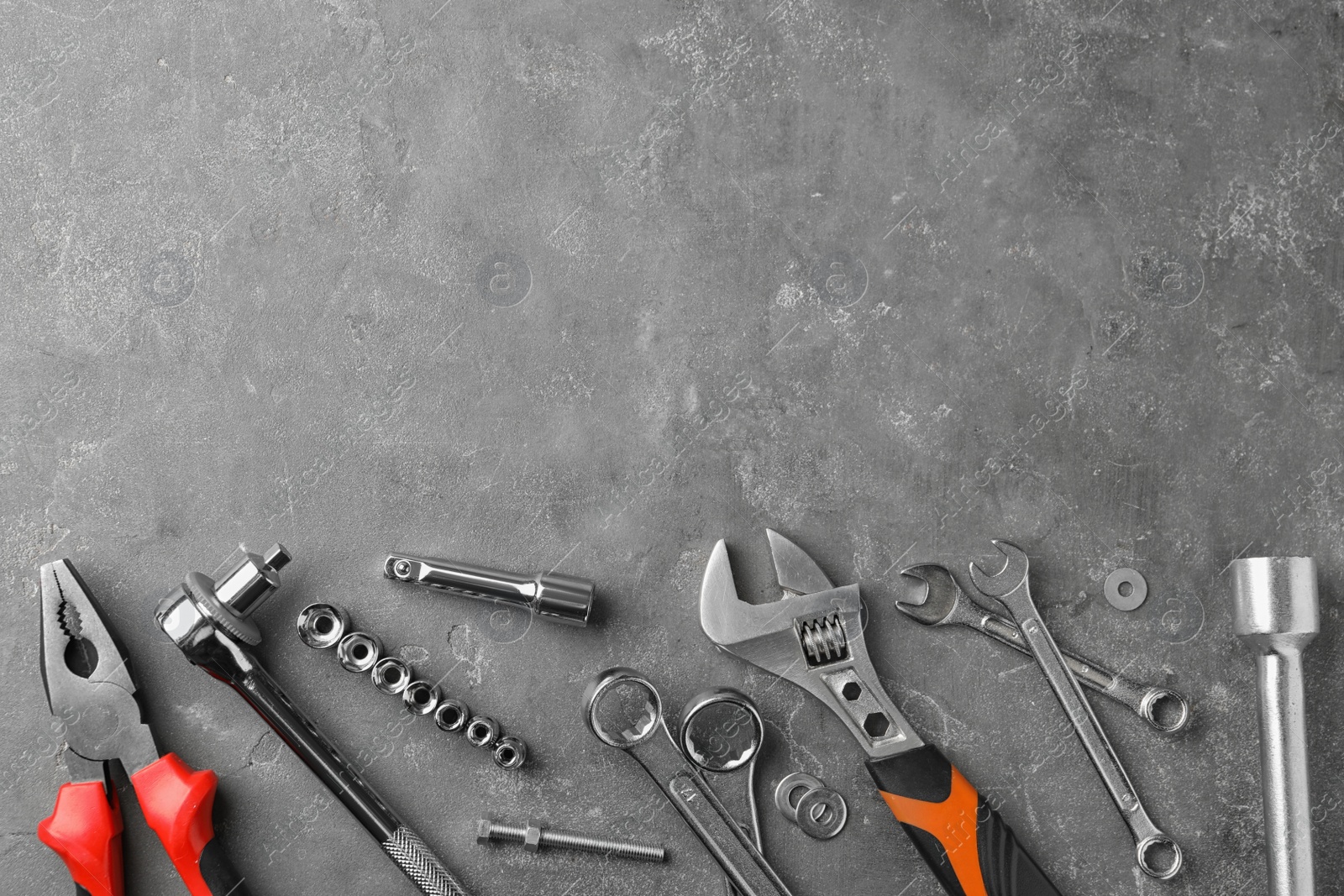 Photo of Auto mechanic's tools on grey stone table, flat lay. Space for text