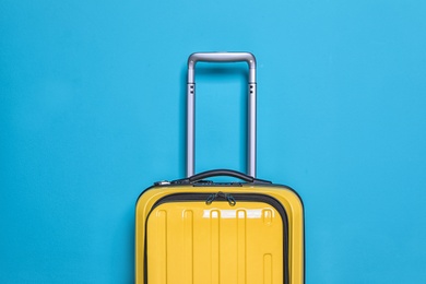 Packed bright yellow suitcase on color background