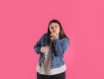 Photo of Beautiful overweight woman posing on pink background. Plus size model
