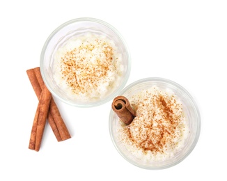 Photo of Creamy rice pudding with cinnamon in glasses on white background, top view