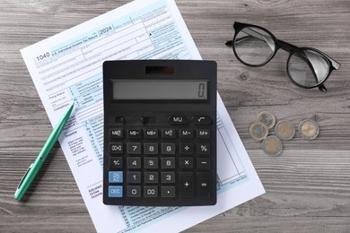 Photo of Tax accounting. Calculator, document, pen and coins on wooden table, flat lay