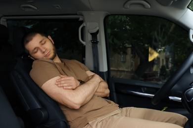 Tired man sleeping in his modern car