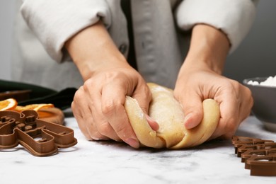 Photo of Woman kneading dough for cookies at white marble table, closeup