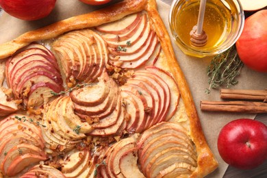 Freshly baked apple pie with nuts and ingredients on wooden table, flat lay