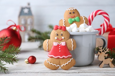 Decorated gingerbread cookies on white wooden table