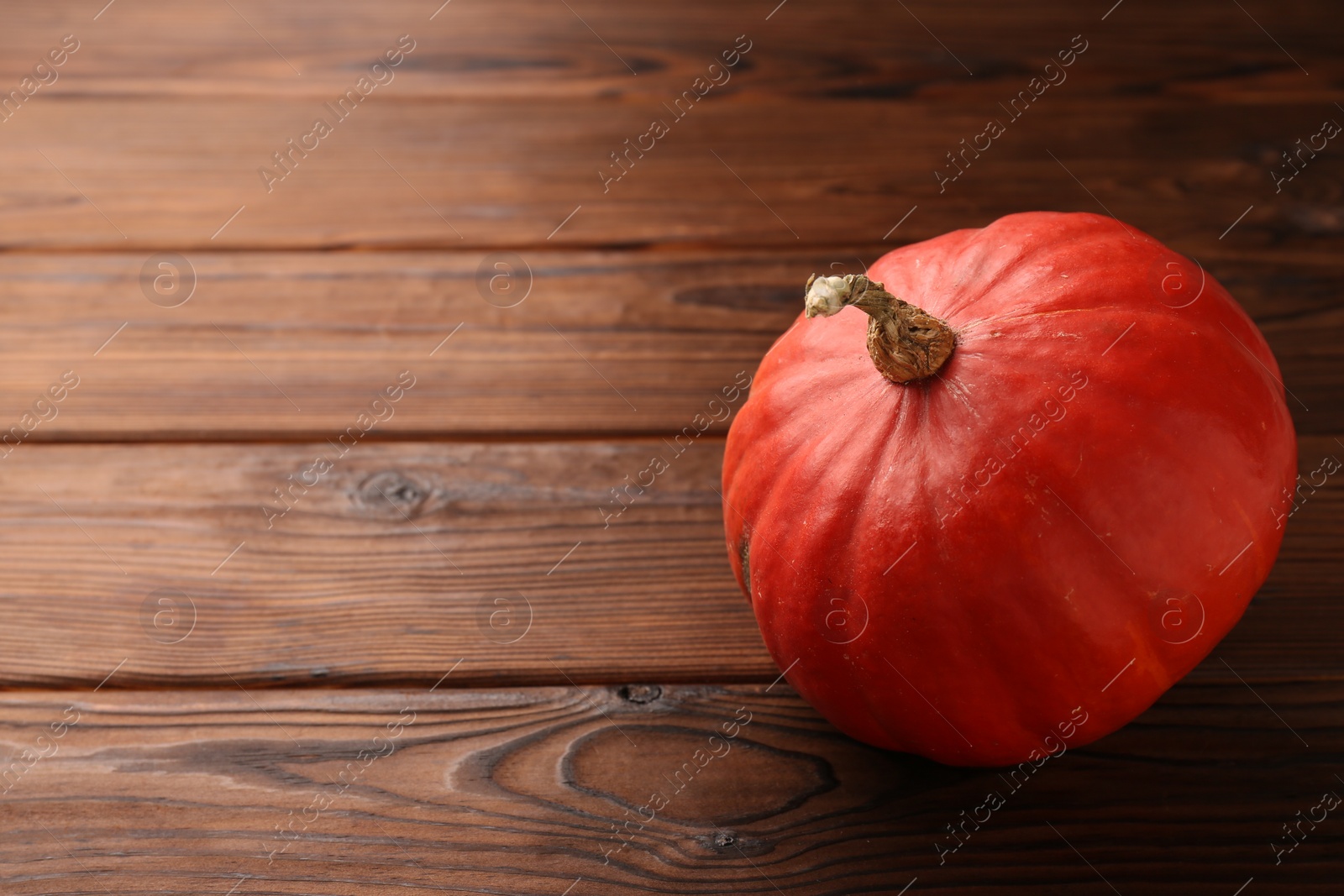 Photo of Fresh orange pumpkin on wooden table. Space for text