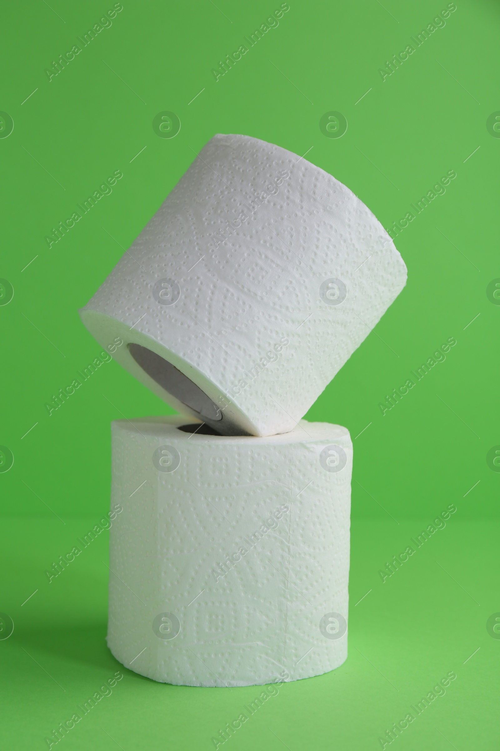 Photo of Soft toilet paper rolls on green background, closeup