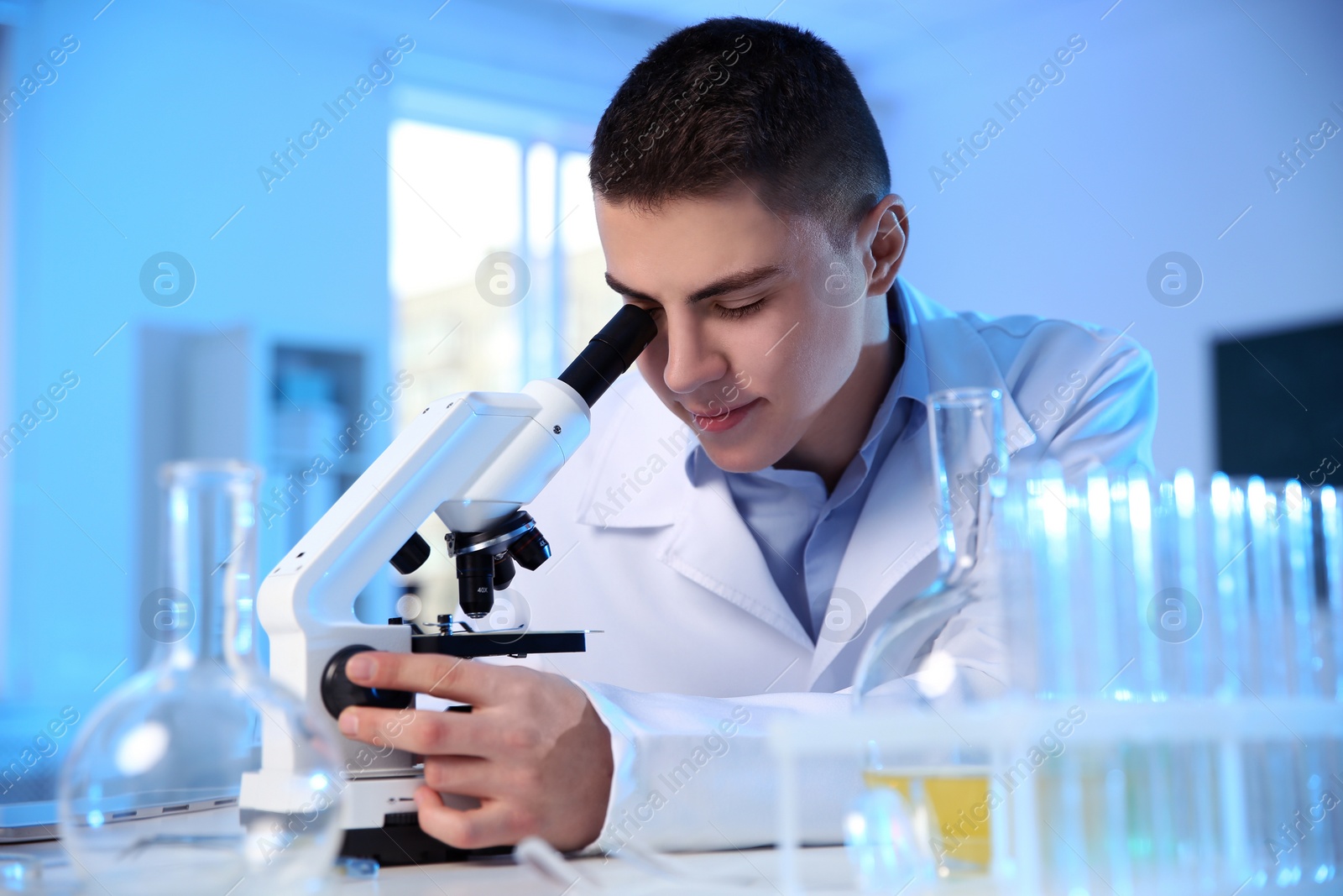 Photo of Male scientist using modern microscope in chemistry laboratory