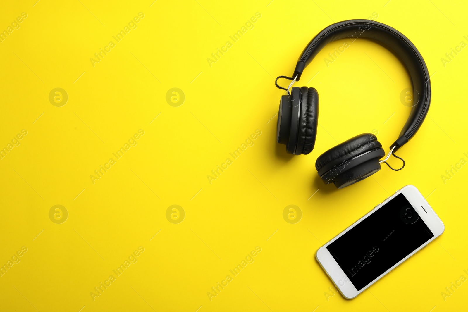 Photo of Stylish headphones and modern phone on color background, flat lay. Space for text