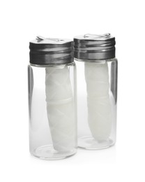 Photo of Rolls of natural organic dental floss in jars on white background
