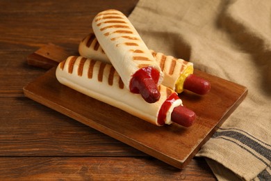 Photo of Delicious french hot dogs on wooden table