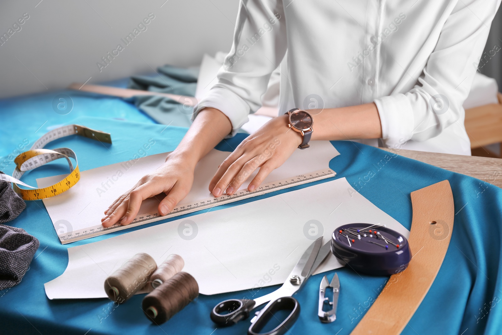 Photo of Tailor working at table in atelier, closeup