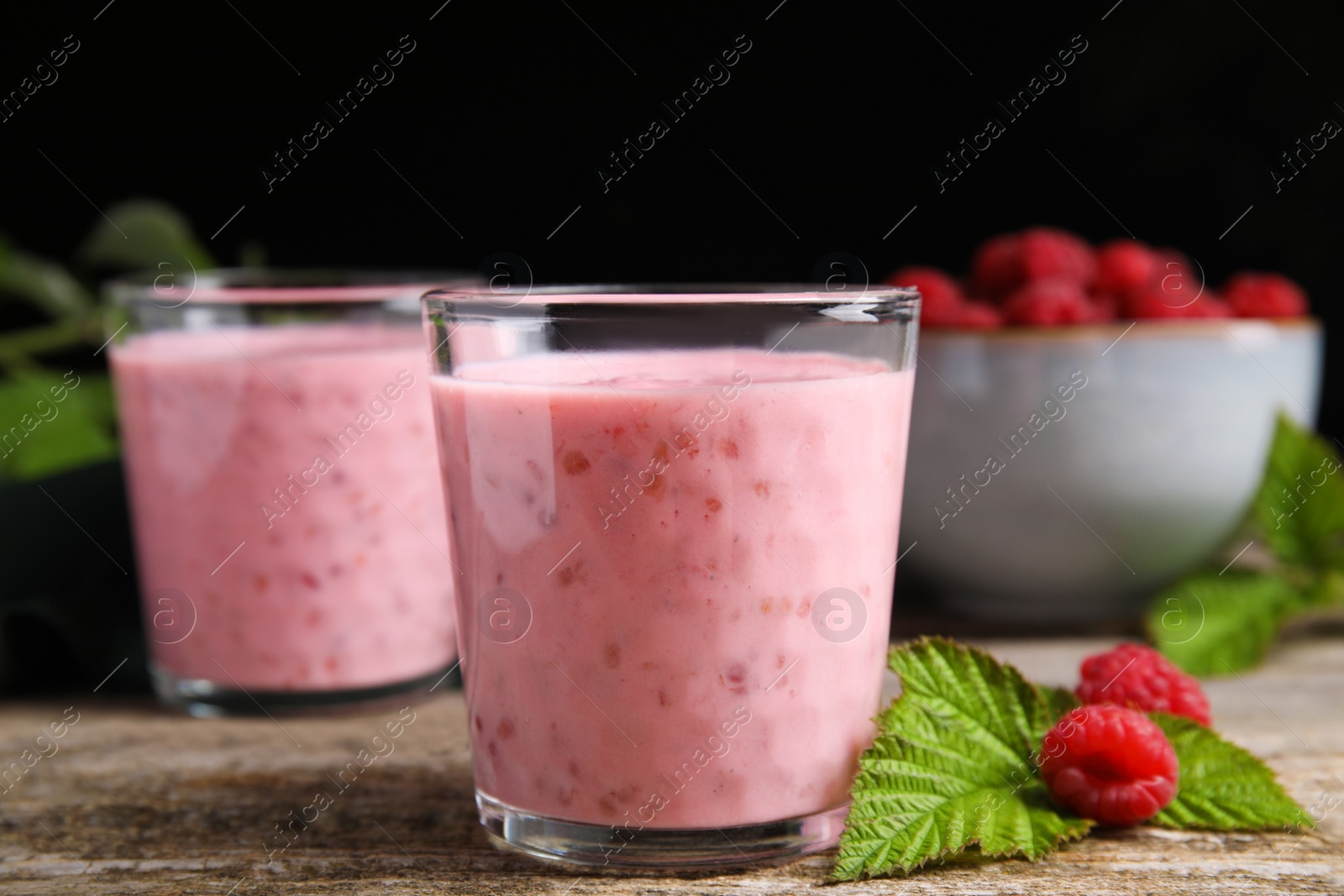 Photo of Tasty raspberry smoothie and fresh berries on wooden table, closeup