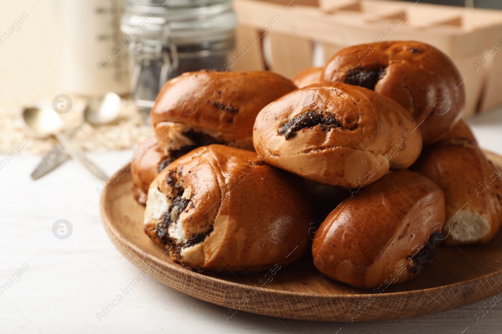 Photo of Plate with freshly baked poppy seed buns on table