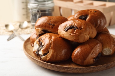 Photo of Plate with freshly baked poppy seed buns on table