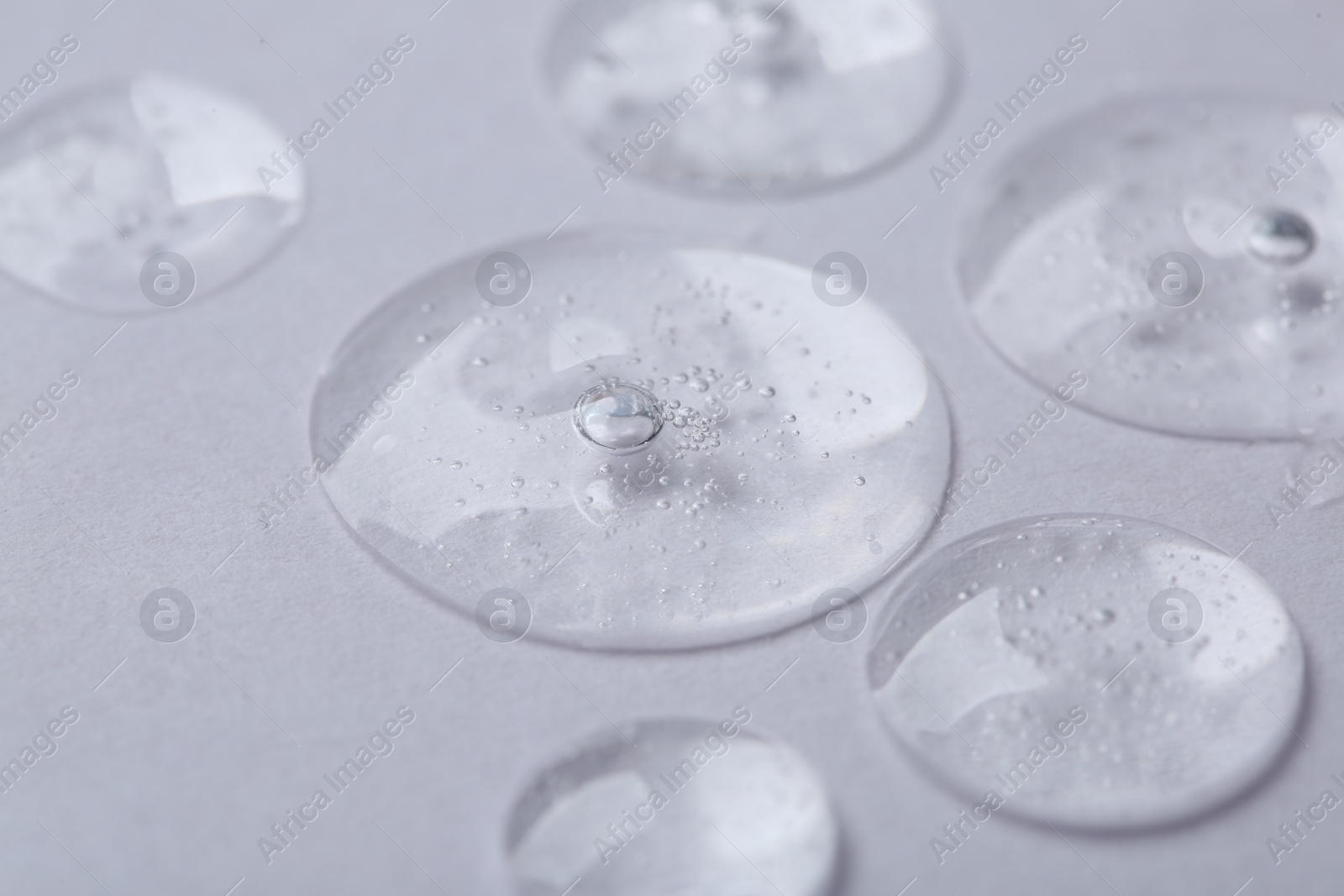 Photo of Samples of cosmetic serum on white background, closeup